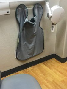 lead apron hanging next to a dental xray machine
