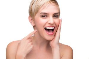 woman smiling and pointing to her new smile